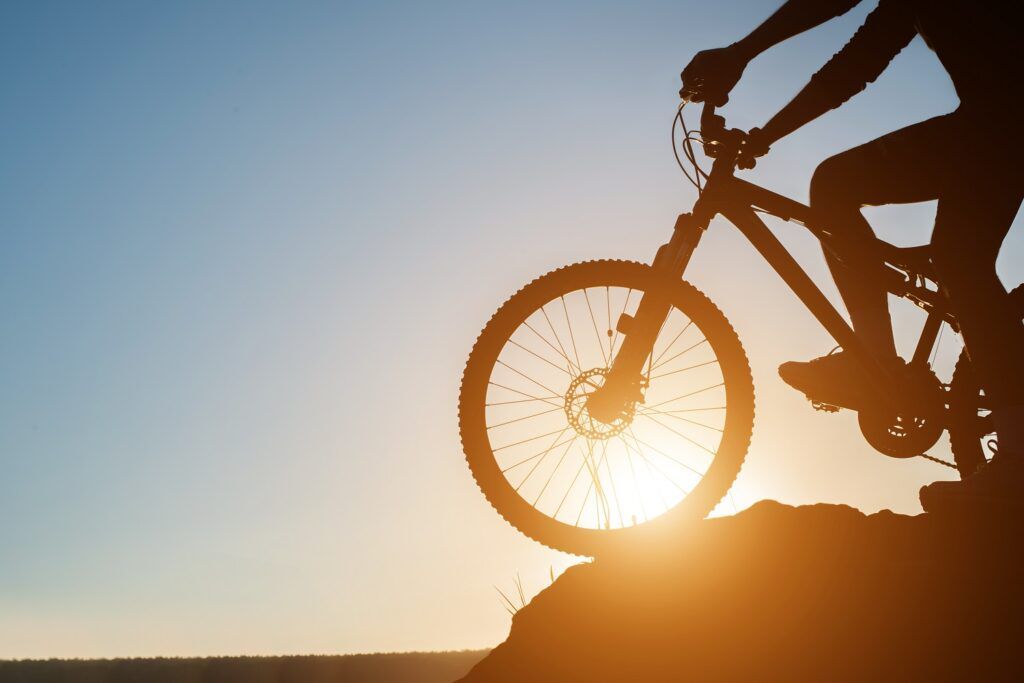 Silhouette of a man on mountain-bike during sunset.